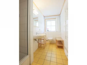 Bad mit Dusche und Fenster in Ferienwohnung im Strandhaus Wiek beim Fasten Retreat auf Rügen.